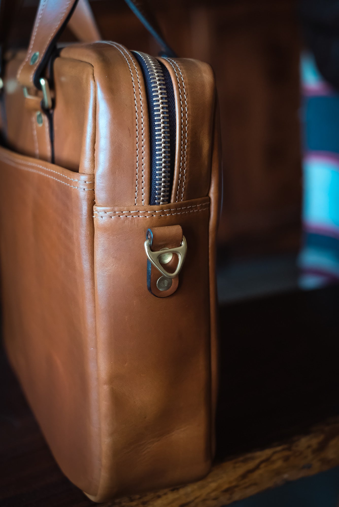 Close-up of Riri zipper and solid brass D-ring on Vachetta leather briefcase