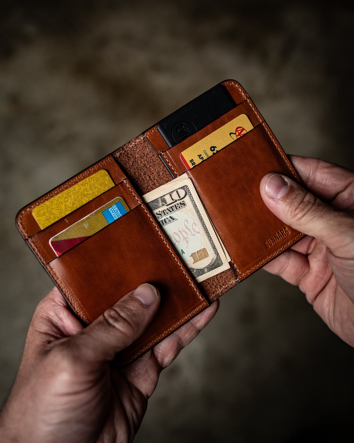 Handmade vertical leather wallet in brown, filled with cash and cards – Gunnar & Co’s Frank wallet.