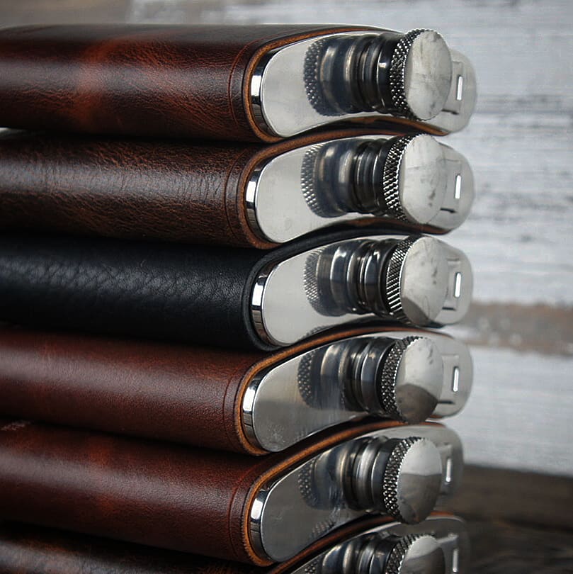 close-up of stacked steel flasks caps - each wrapped in premium full-grain leather by Gunnar & CO.