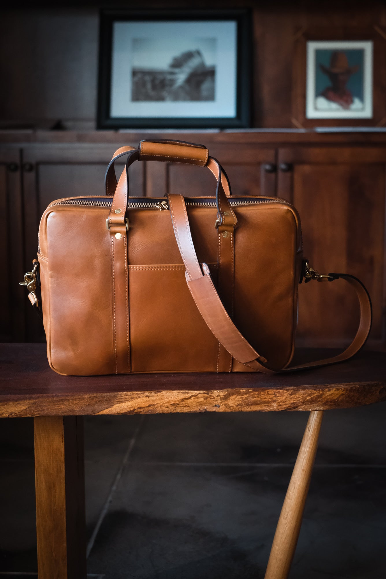 Handmade briefcase with detachable shoulder strap on rustic table