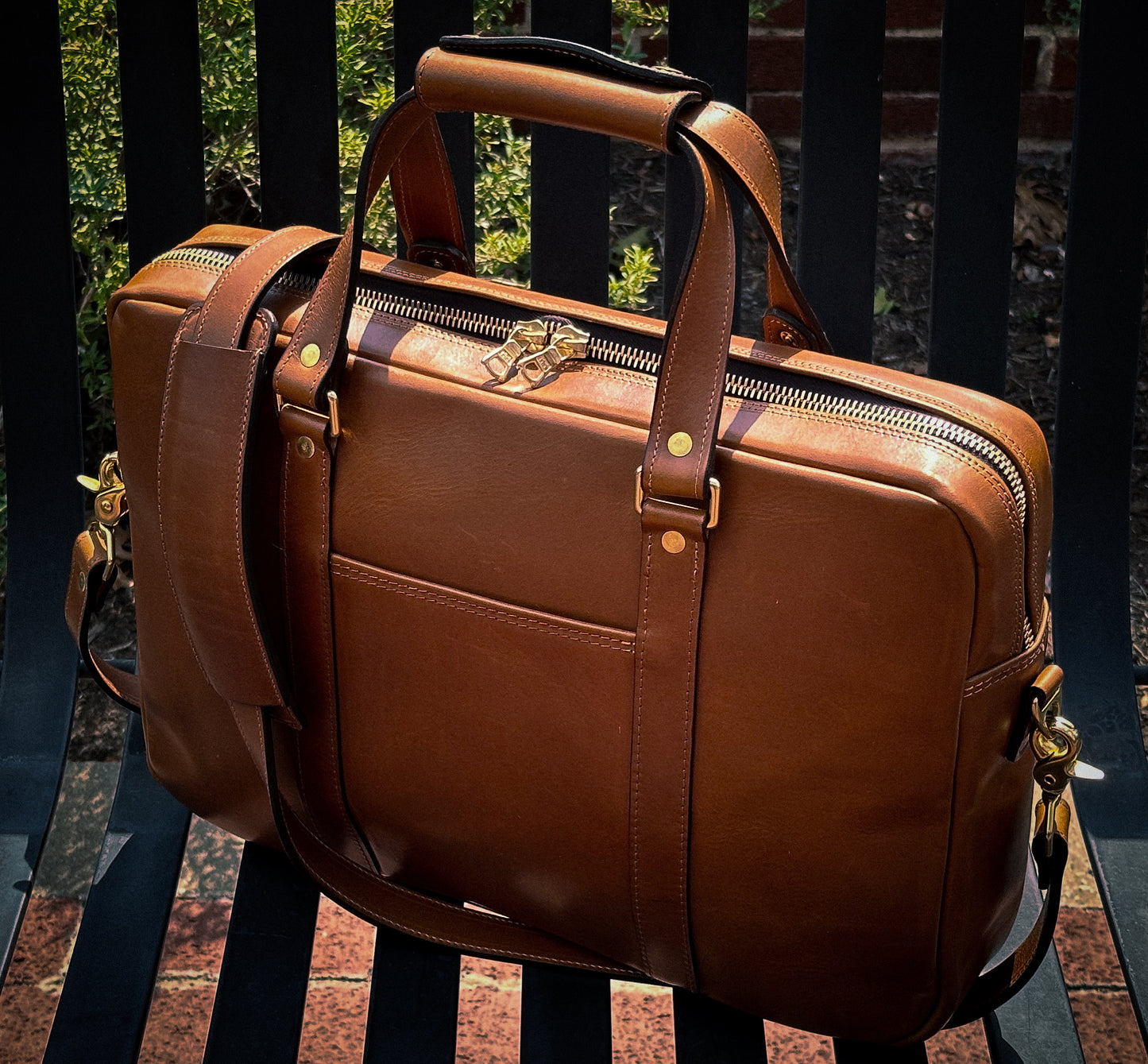 Leather briefcase resting on a bench with natural light