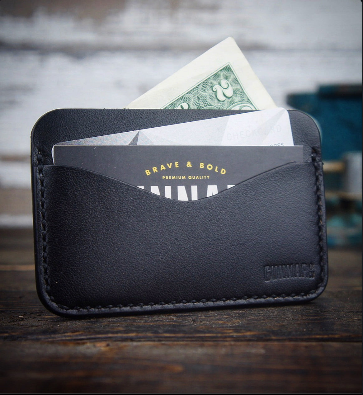 Black leather card wallet with cash showing in top pocket