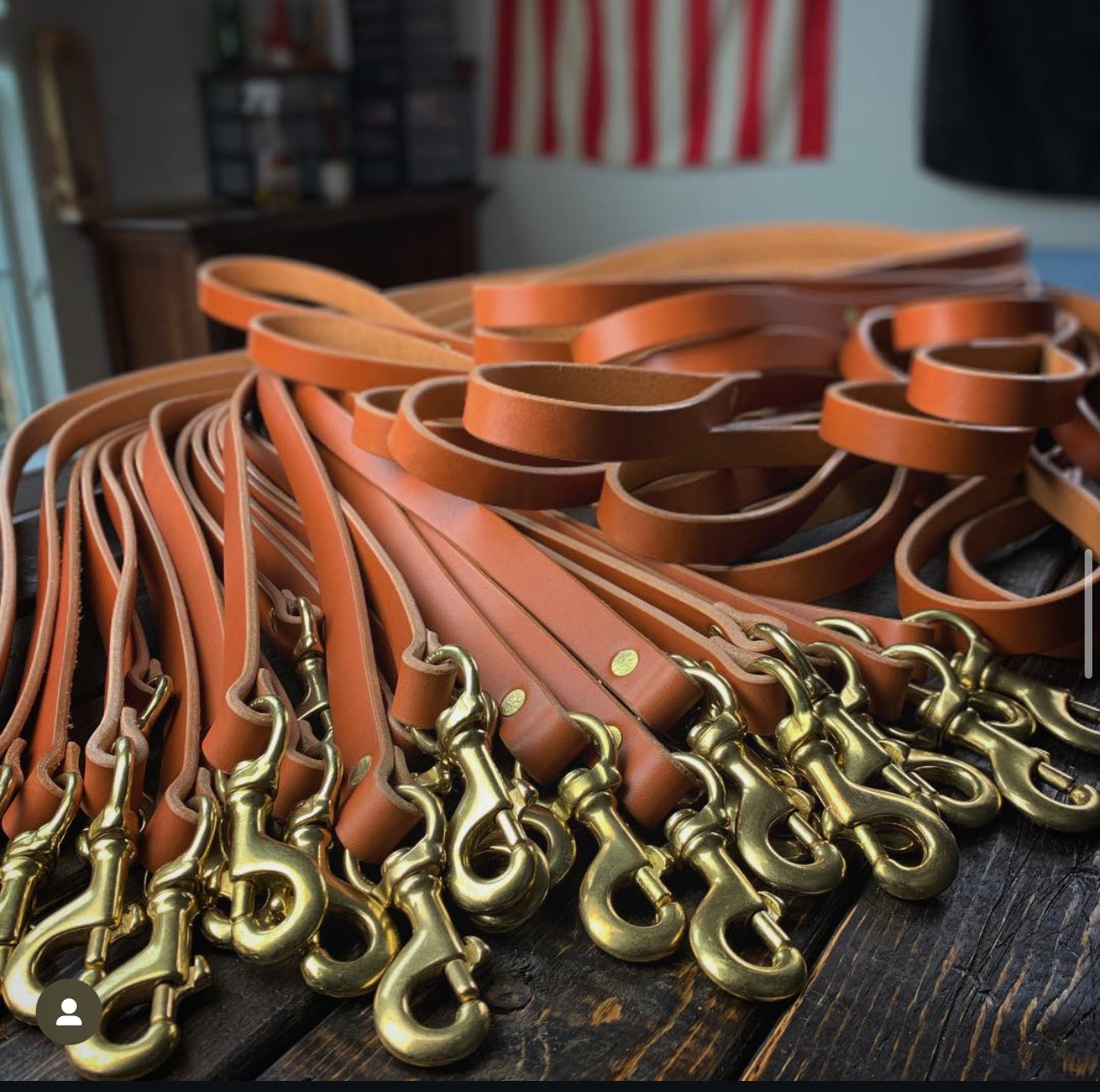 Handcrafted leather dog leashes with solid brass hardware by Gunnar & Co., made in Texas and laid out on a rustic wood workbench.