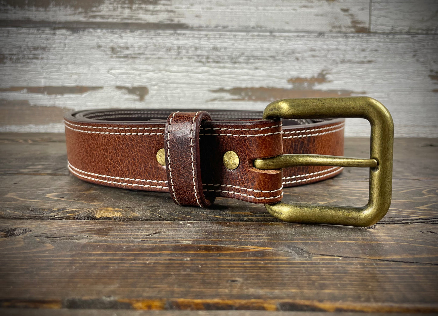 Belt laid flat to display stitched edges and solid buckle