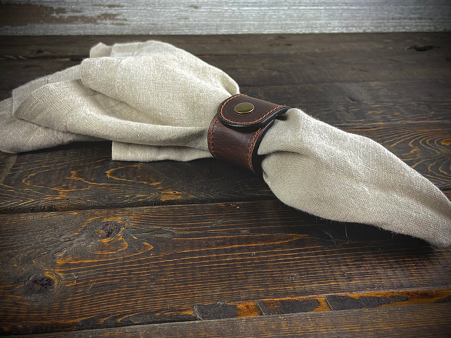 Rustic leather napkin rings displayed on folded napkins – made in Texas and perfect for weddings, homes, or bulk orders.