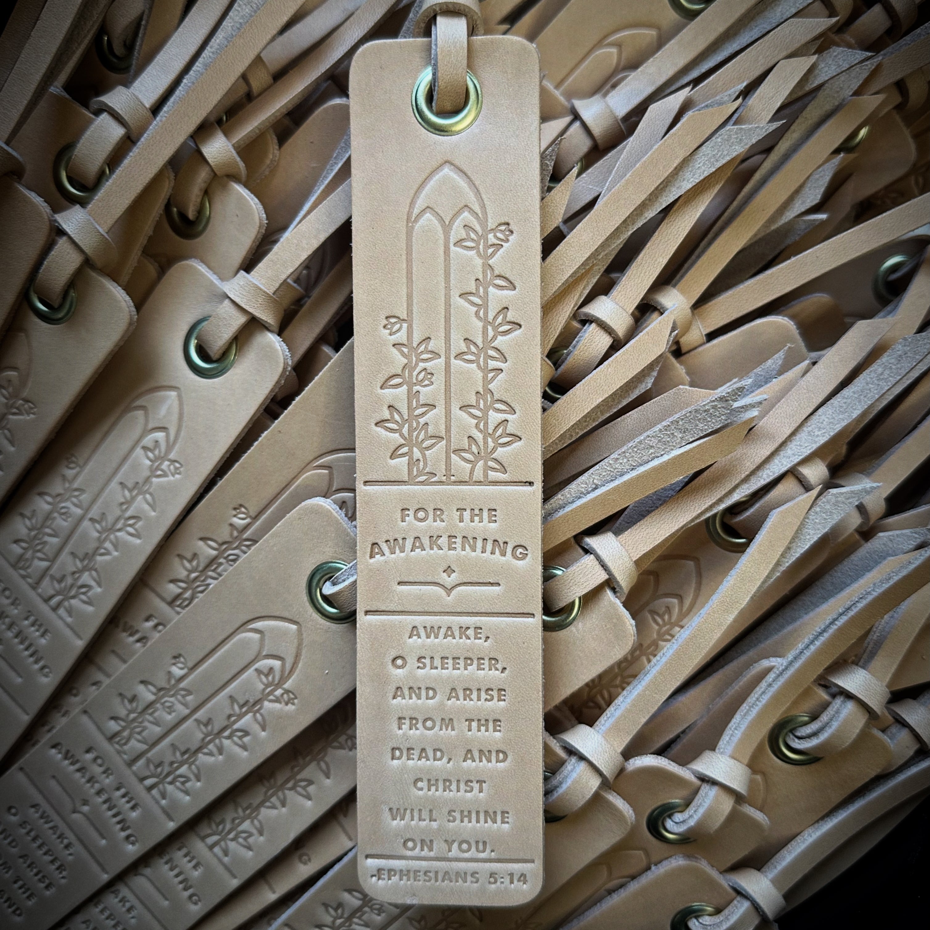 Custom tan leather bookmarks by Gunnar & Co., featuring stamped scripture and grommet detail, handcrafted for a faith-based bulk order.